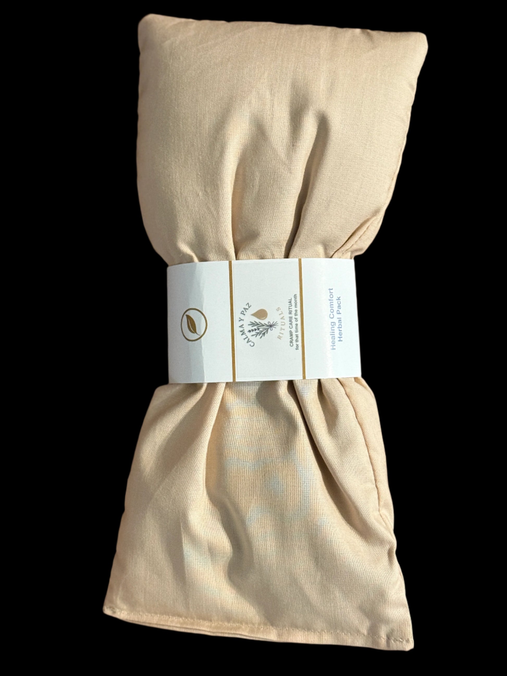 Healing comfort herbal pack beige fabric folded with a label on a wooden surface.